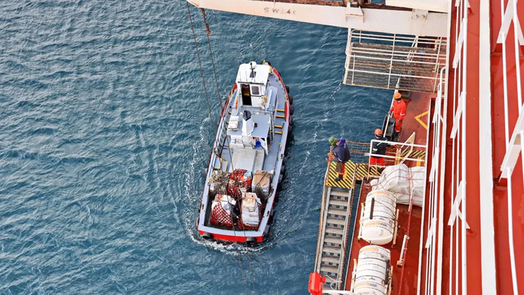 Supply launch alongside a tanker delivering ship's stores