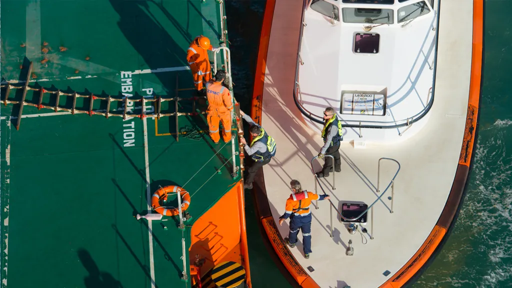 Crew transferring between a pilot boat and a vessel