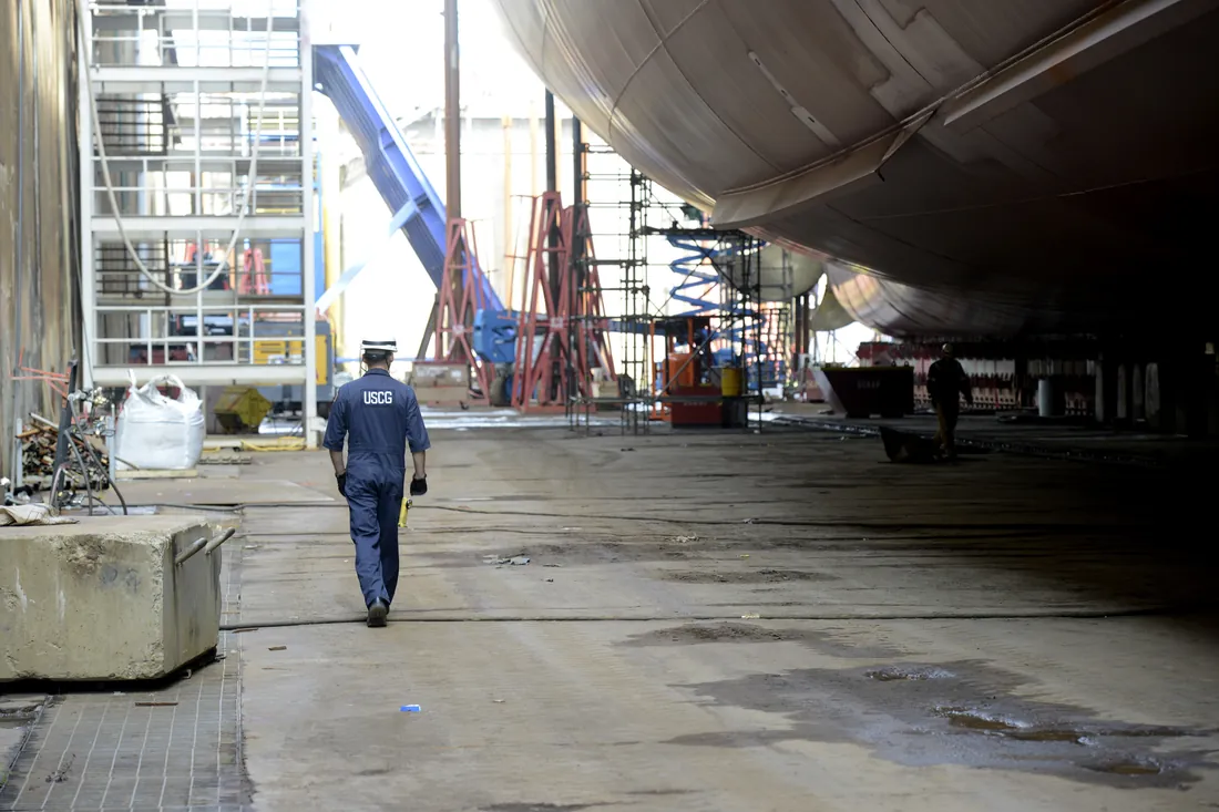Marine surveyor inspecting a vessel's hull in dry dock