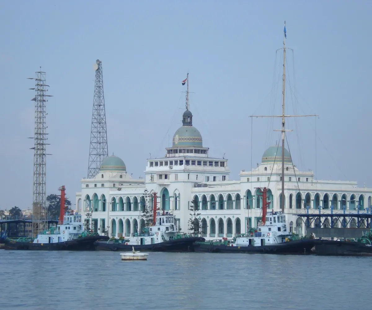 Suez Canal Authority building on the waterfront in Port Said, with harbour tugs moored in front